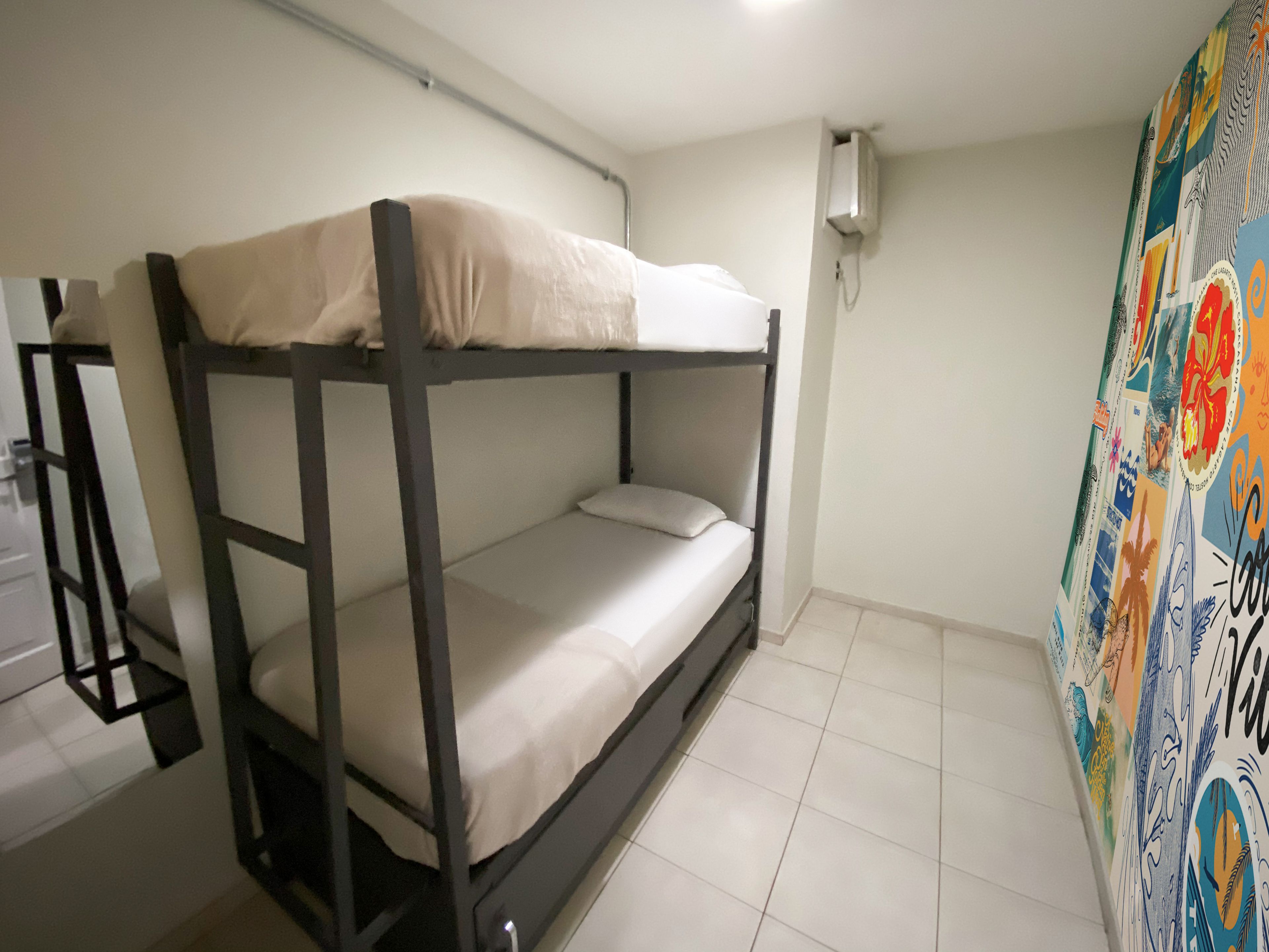 A bunk bed in a room with white walls and a tiled floor.