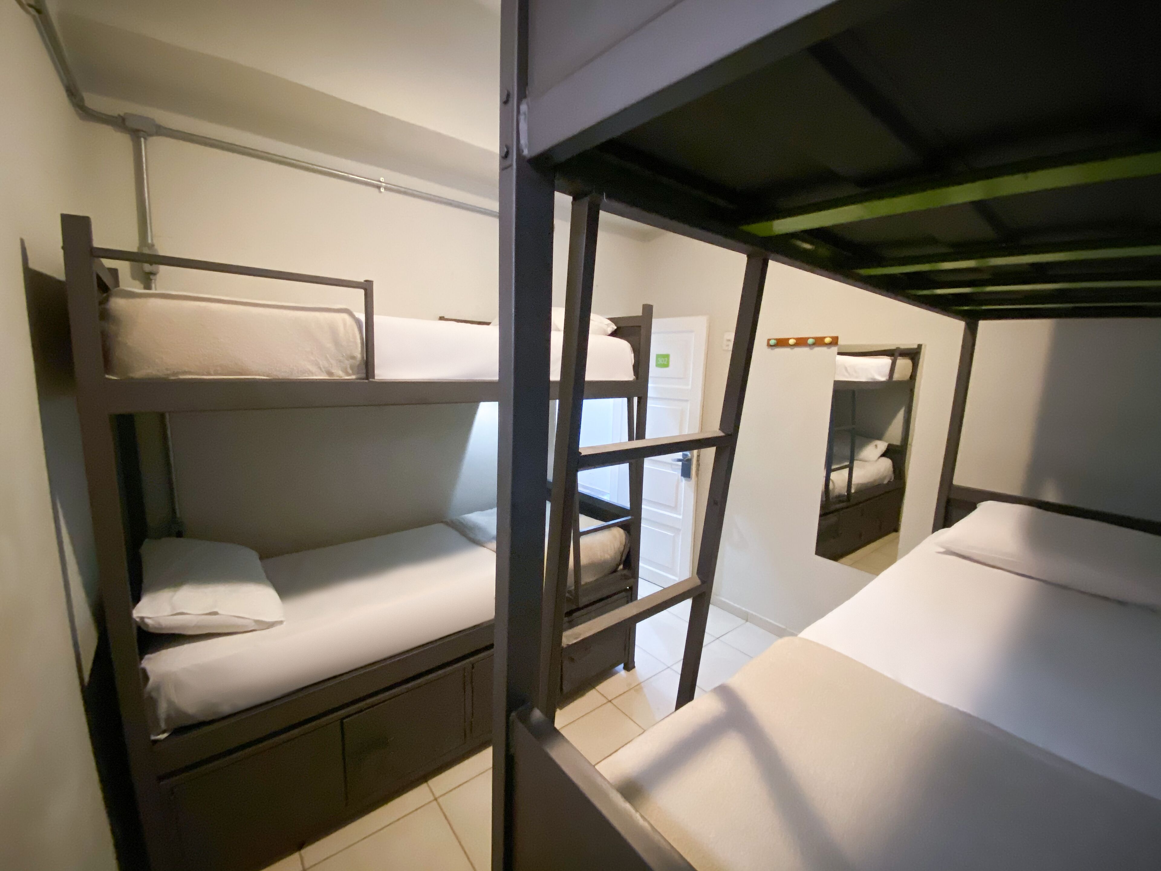 A bunk bed room with a ladder, a door, and a small table.