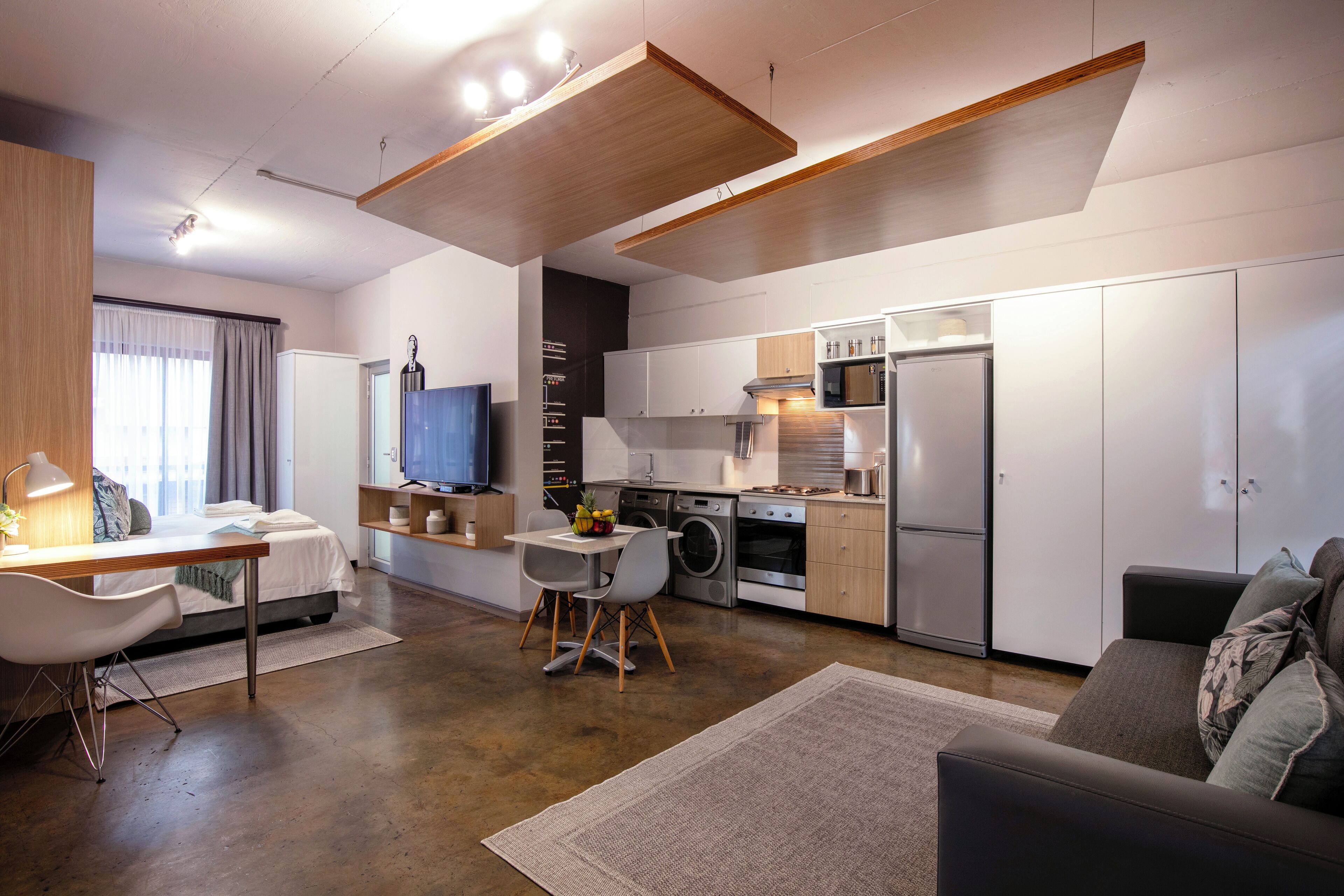 A modern apartment with a kitchen, dining area, and living room.