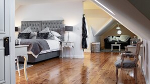 Une chambre à coucher avec un grand lit, une table de chevet, une chaise et une petite table.