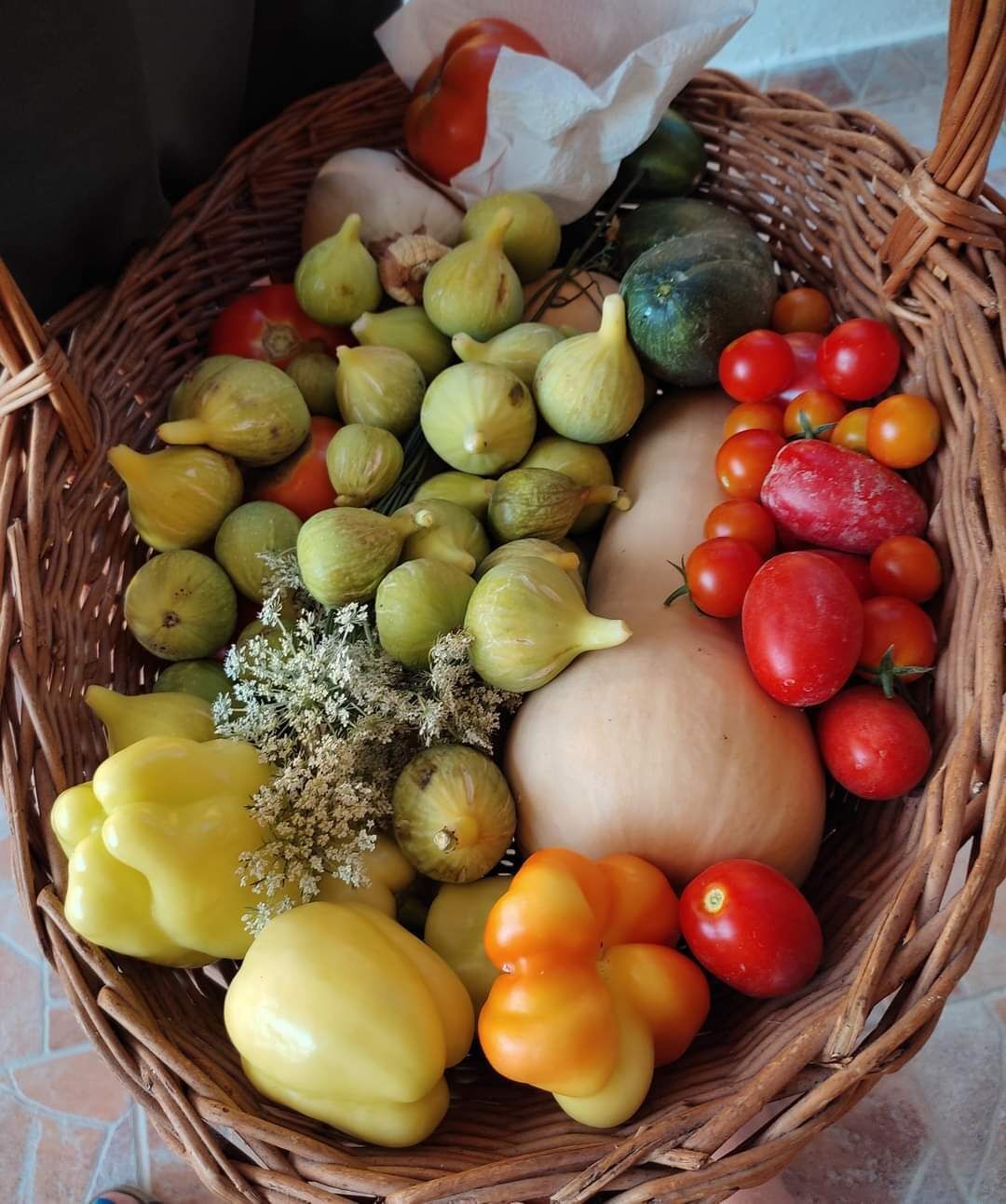 A wicker basket filled with various fruits and vegetables.