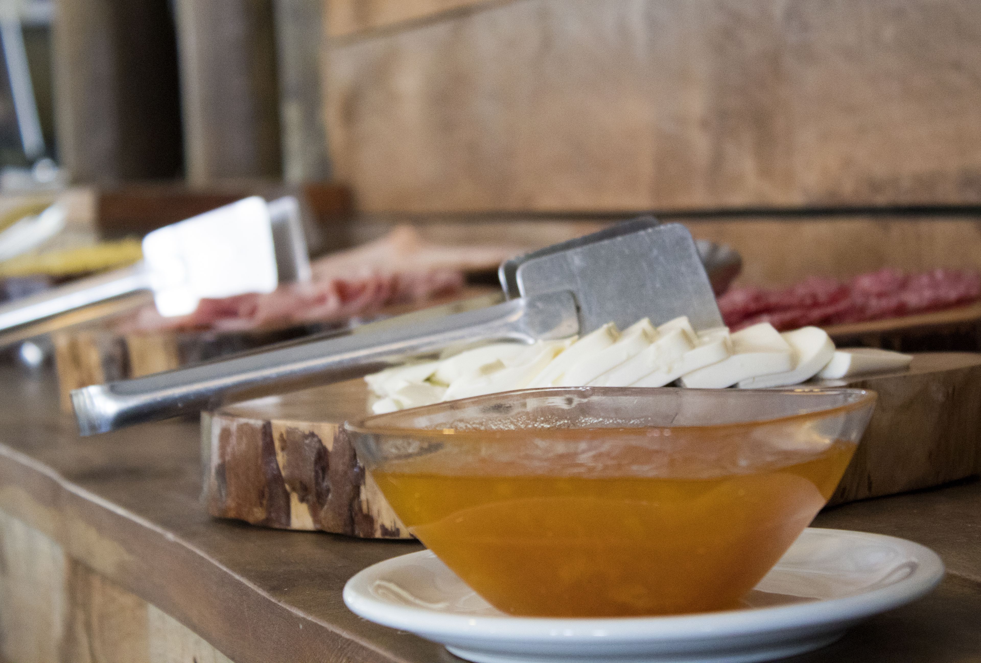 Una tabla de madera con un cuchillo y un tazón de sopa.