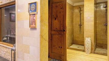 A spa room with a wooden door, a shower area, and a patterned floor.