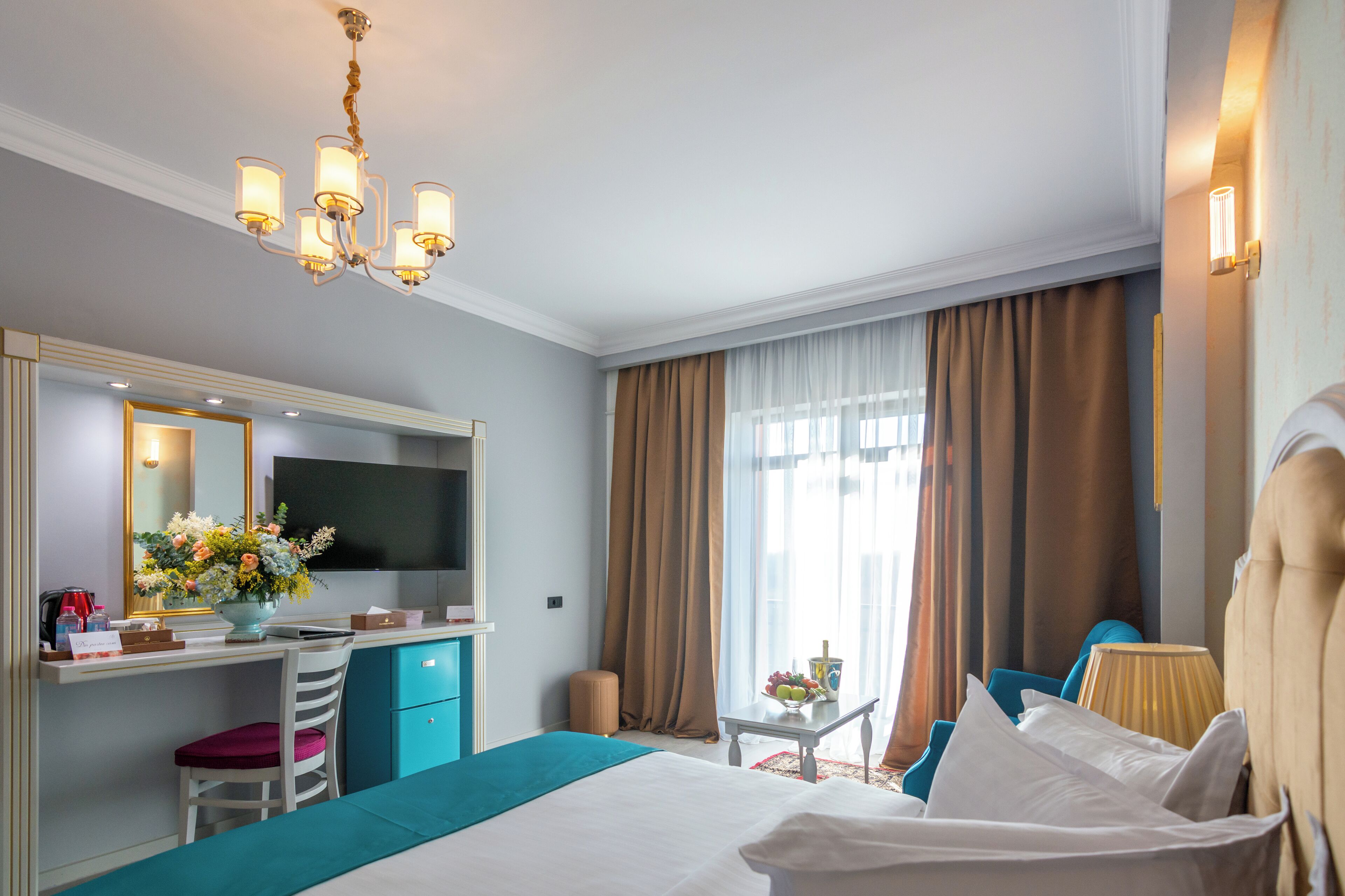 Una habitación de hotel con cama, escritorio, silla y televisor.