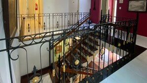 A multi-level interior with a staircase, a chandelier, and a fire extinguisher. - Pousada Minas Gerais (Ouro Preto)