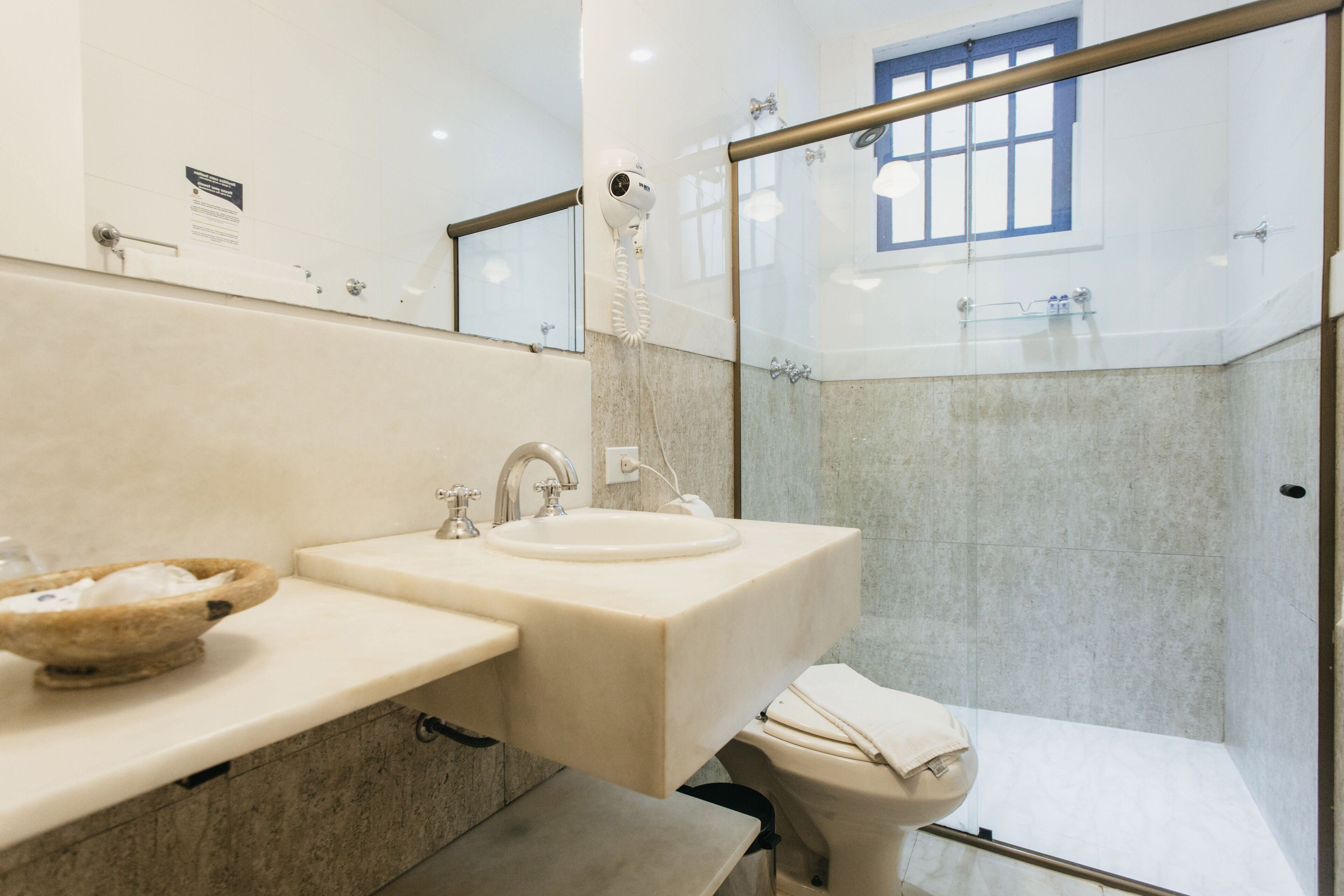 A modern bathroom with a sink, mirror, and a glass shower enclosure.