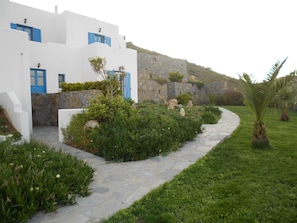 A white building with blue shutters and a stone wall. - Dream View Hotel (Naxos)