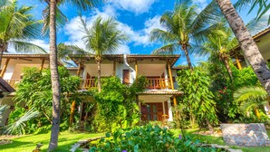 A resort with a pool, palm trees, and a well-maintained garden. - Vila Coqueiros (Caucaia)