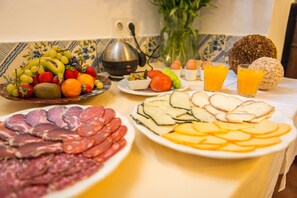 Un bufé de desayuno con diversas opciones de comida, incluyendo frutas, verduras, huevos y carnes.