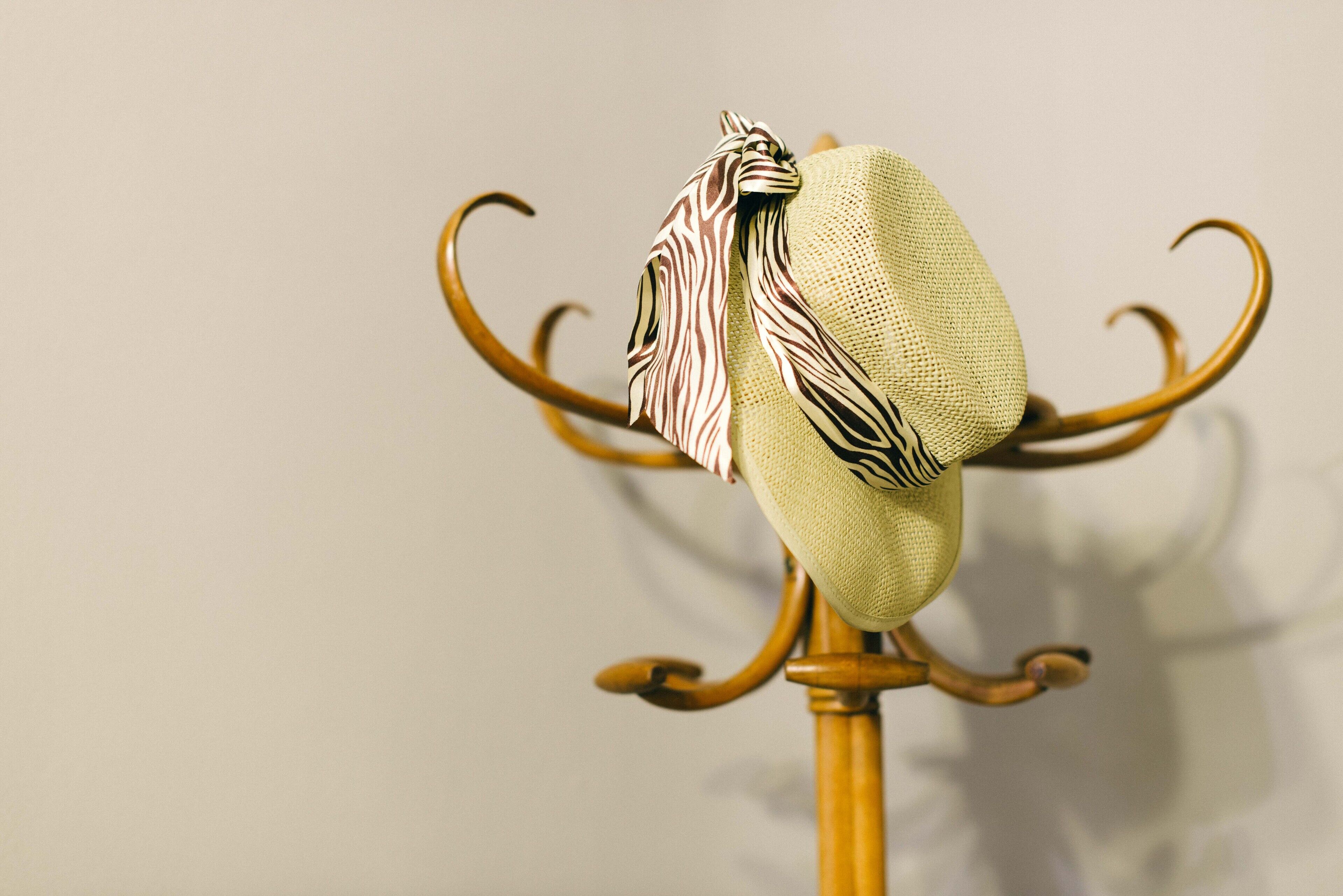 Un sombrero sobre un soporte metálico, sobre fondo neutro.