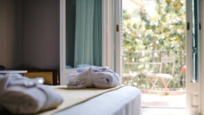 Una habitación de hotel con una cama, una ventana y vistas a un balcón.