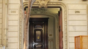 Una entrada imponente con una puerta de madera oscura, detalles ornamentales y los números 286 y 288 en las paredes.