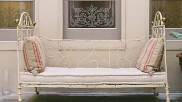 Un banco de metal blanco con almohadas a rayas rojas y blancas.