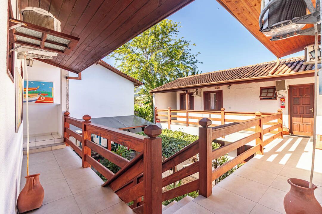 A courtyard with wooden railings, a tiled floor, and a building with a tiled roof.