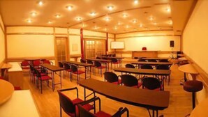 A conference room with multiple tables and chairs, a projector screen, and a whiteboard. - London Palace Hotel (Montevideo)