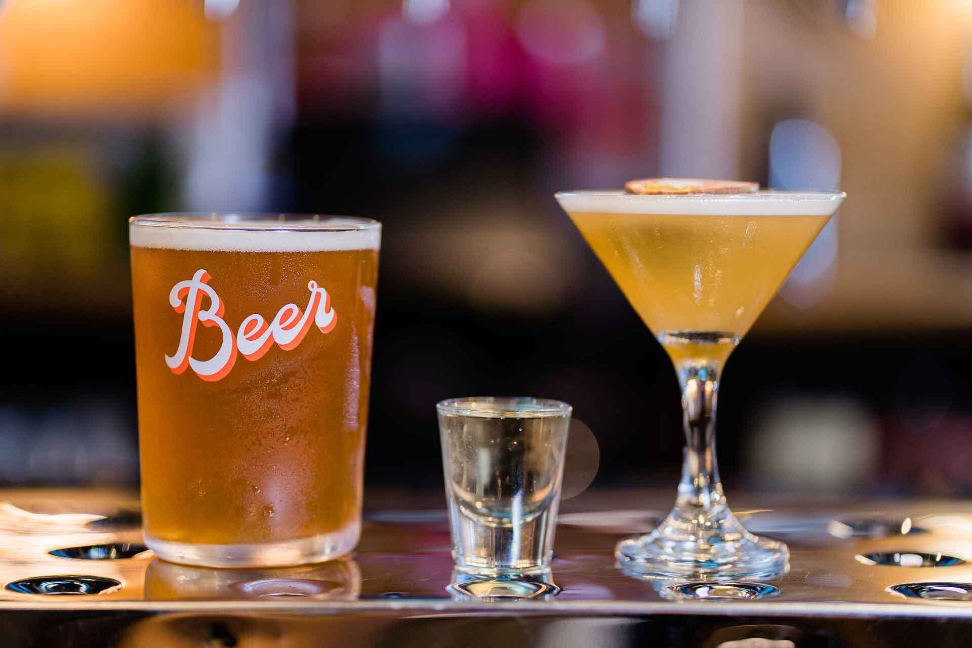 A bar setting with a glass labeled "Beer," a martini glass, and a shot glass.