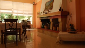 Un área de comedor con chimenea, sillas y mesas.