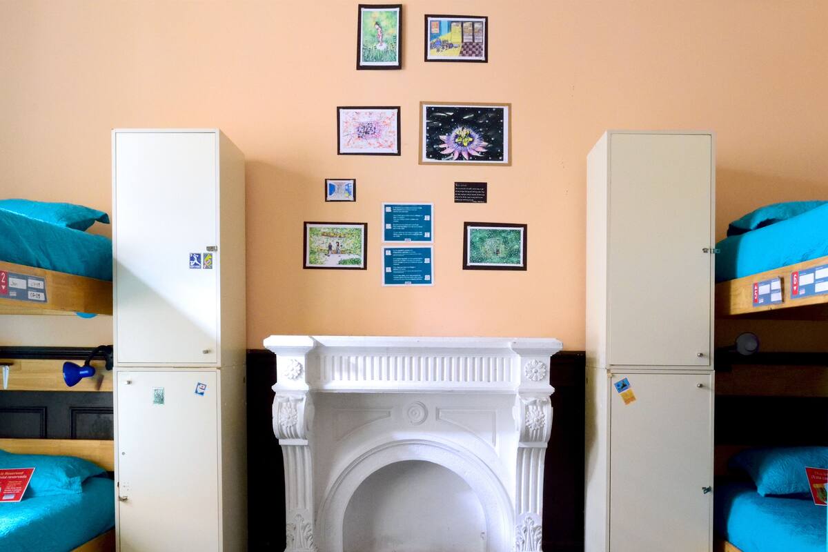 Un dormitorio con literas, chimenea y obras de arte en las paredes.