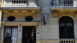 A building with classical architecture, featuring ornate balconies, large windows, and decorative moldings.