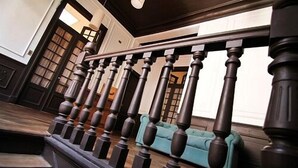 A staircase with dark wooden balusters and a teal sofa in the background.