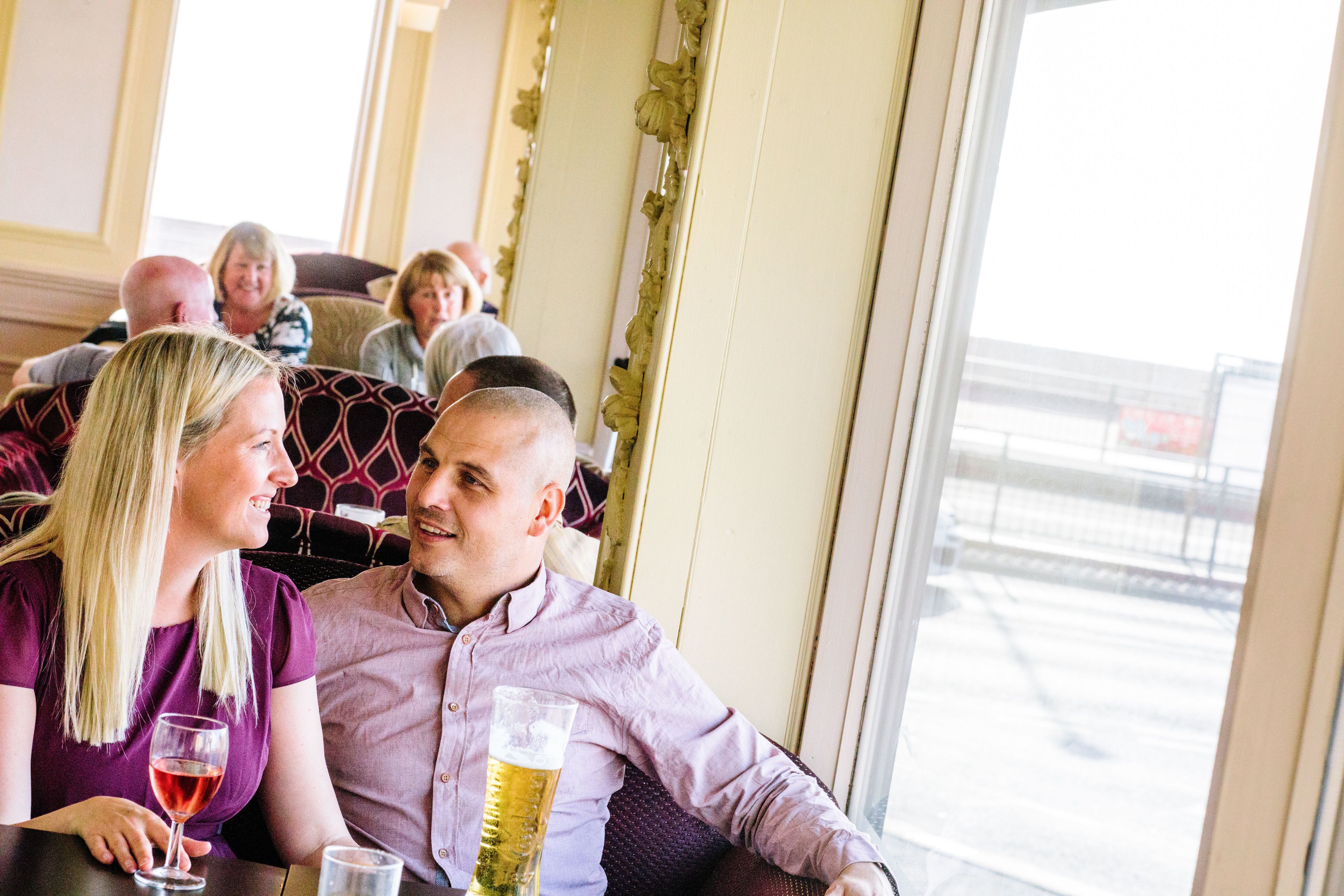 Una pareja sentada en una mesa de restaurante con vistas al exterior.
