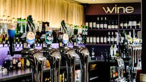 Eine Bar mit mehreren Bierhähnen und einem Weinkeller im Hintergrund.