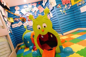 A children's play area with a slide and colorful foam mats.