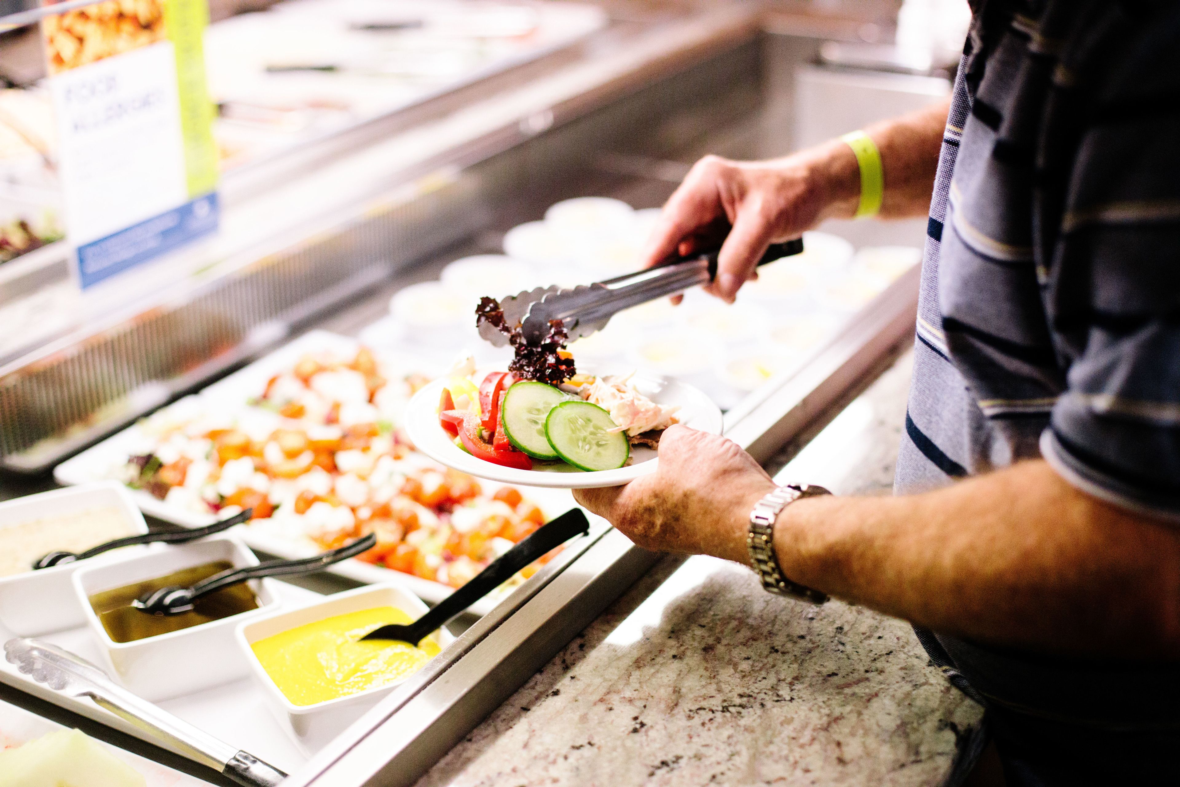 A buffet setup with various food items and condiments.