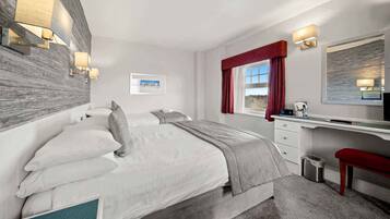 Een moderne hotelkamer met een groot bed, een bureau en uitzicht op de omgeving.