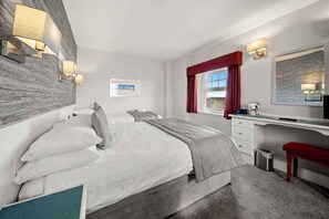 Cortinas opacas, tabla de planchar con plancha, ropa de cama
