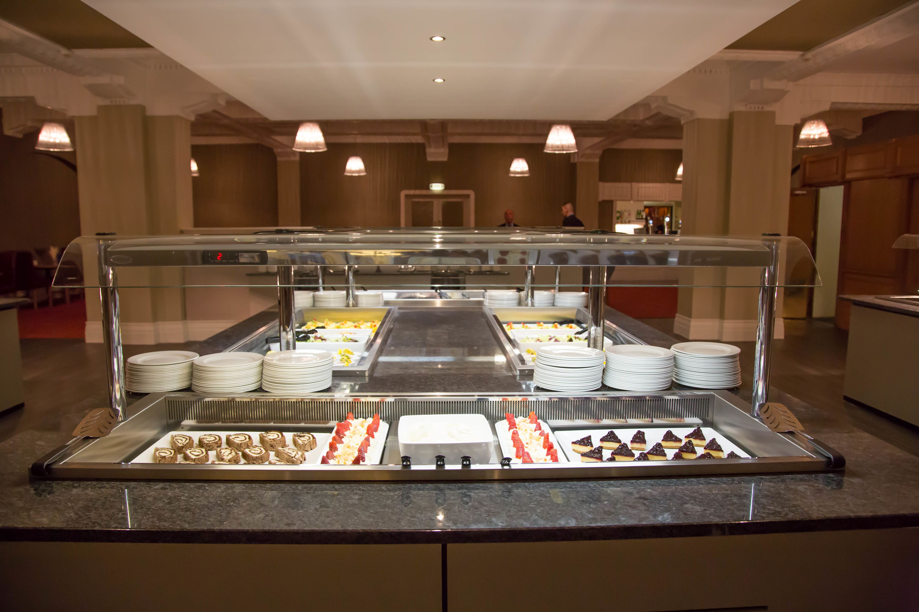 A buffet setup with various food items and plates.