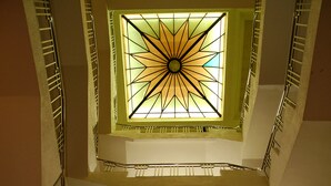 A multi-level interior with a central skylight and metal railings.