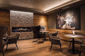 Un interior moderno con chimenea, una zona de estar y una obra de arte grande en la pared.