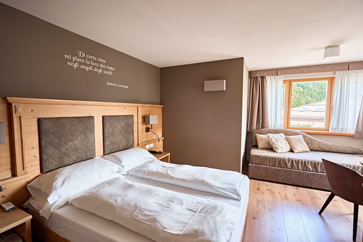 A neatly arranged bedroom with a bed, bedside table, and a window with curtains.