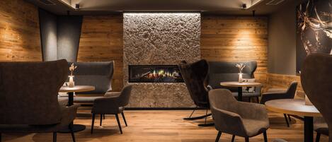 Un espace salon accueillant avec une cheminée, des sièges confortables et un design moderne.