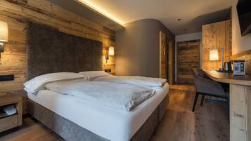 A modern hotel room with a large bed, a desk, and a chair.