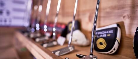A row of golf clubs on a wooden rack.