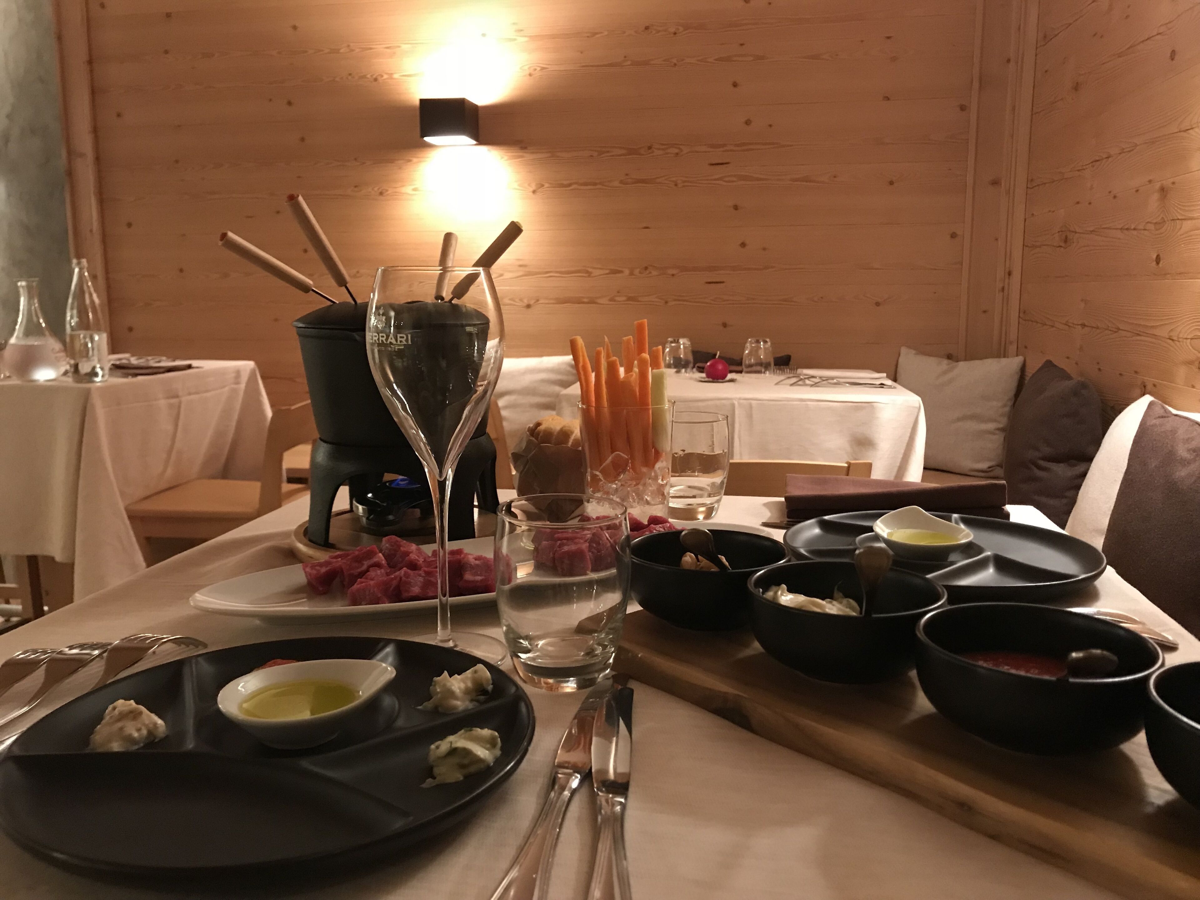 A dining table set with various dishes, including a glass of wine, bowls of food, and utensils.