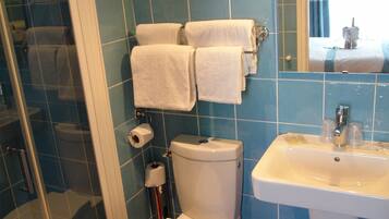 Un baño con inodoro, lavamanos y ducha.