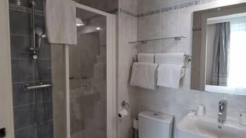 A modern bathroom with a glass-enclosed shower, a toilet, and a sink.