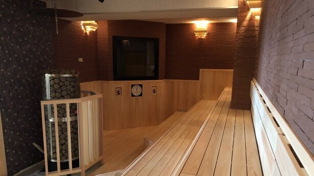 A sauna area with wooden benches and a wall-mounted heater. - Golden Time Takamatsu (Takamatsu)