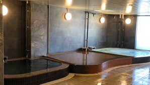 A spa area with three hot tubs and a wooden bench. - Golden Time Takamatsu (Takamatsu)