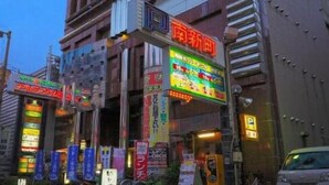 A multi-story building with a prominent red sign on the ground floor, possibly indicating a commercial space. - Golden Time Takamatsu (Takamatsu)