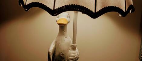 Una lámpara con una figurita de pato sosteniendo un paraguas.