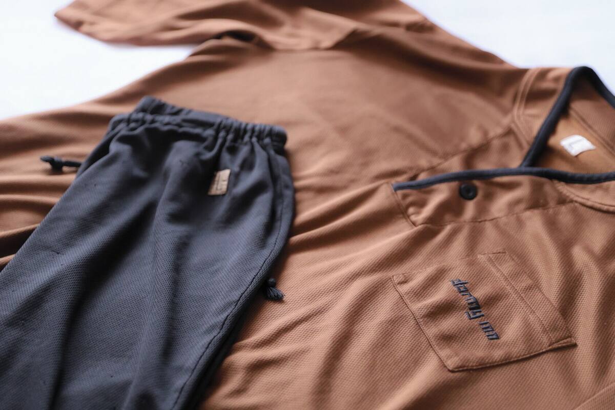 A brown shirt with a drawstring and a pocket with a tag.