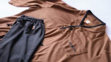 A brown shirt with a drawstring and a pocket with a tag.
