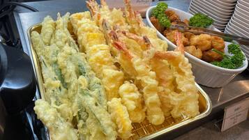 Una bandeja de tempura con camarones y verduras.