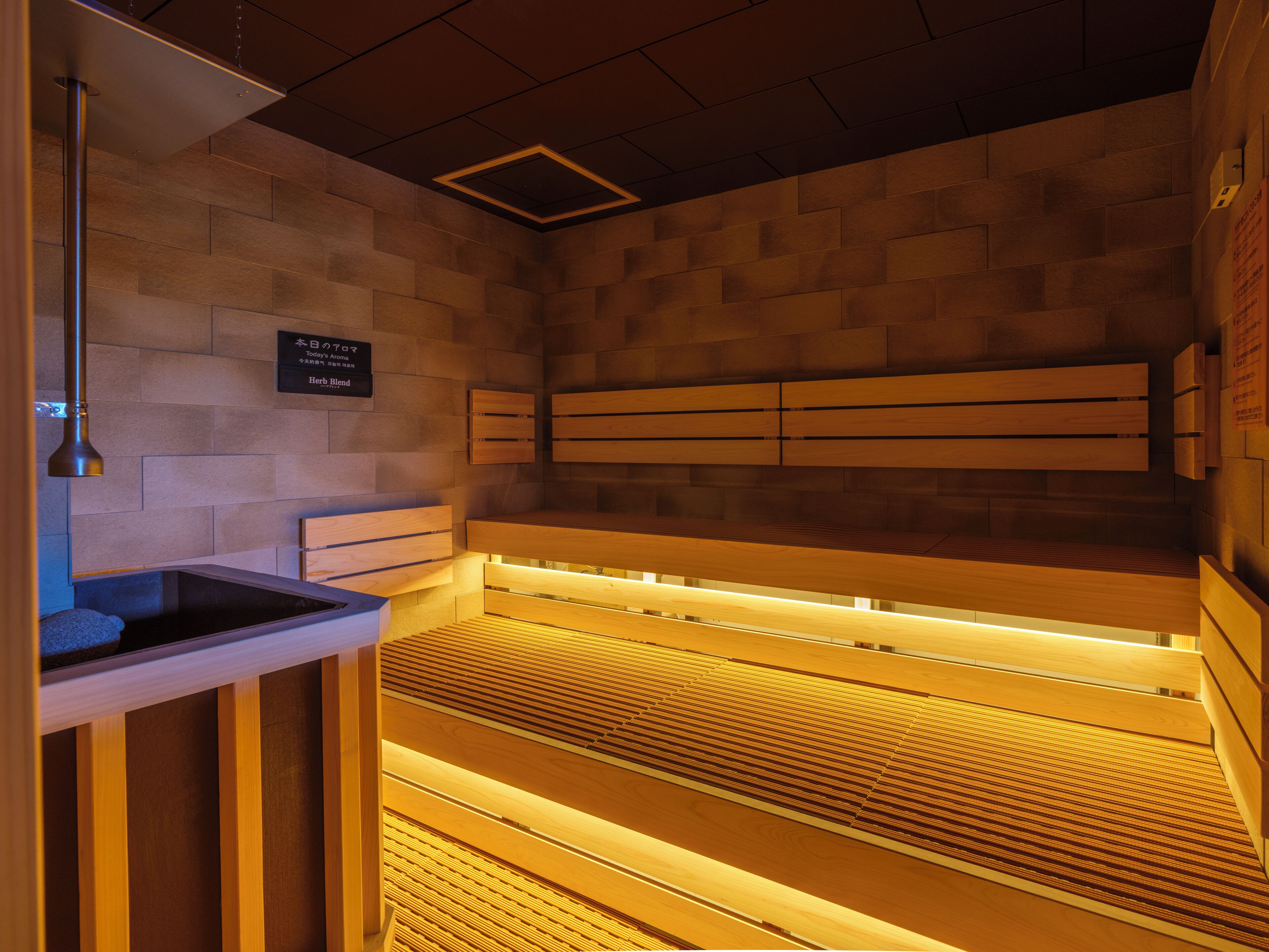 A sauna with wooden benches and a tiled wall.