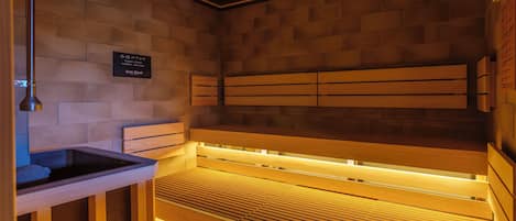 A sauna with wooden benches and a tiled wall.