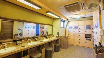 A hotel bathroom with multiple sinks, mirrors, and lockers.
